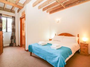 a bedroom with a bed with towels on it at Ohope Barn in Kingsbridge