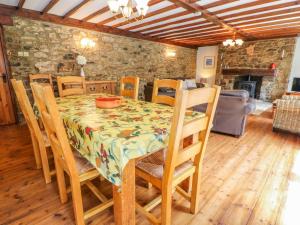 a dining room with a table and chairs and a fireplace at Coth Skyber in Hayle