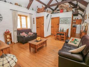 a living room with a couch and a table at Bluebell Cottage in Milford Haven