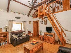 uma sala de estar com um sofá e uma escada em Bluebell Cottage em Milford Haven