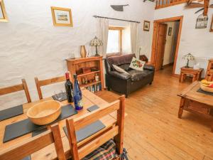 a living room with a table and a couch at Bluebell Cottage in Milford Haven +12 photos