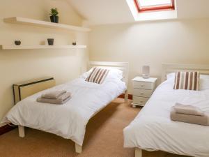 ein Schlafzimmer mit 2 Betten und Handtüchern darauf in der Unterkunft Fawcetts Barn in Skipton