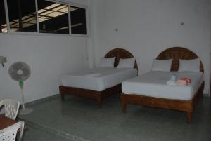 a hotel room with two beds and two lamps at Hospedaje Papagrande in Homún