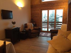 a living room with a chair and a window at Verbier Valmont in center in Verbier