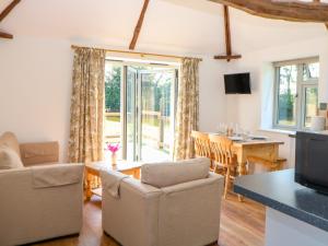 a living room with a couch and chairs and a table at Sparrow Barn in Norwich