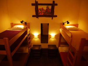 a room with two bunk beds and a mirror at KACLLA, The Healing Dog Hostel in Lima