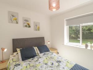 a bedroom with a bed and a window at Orchard Annexe in Lymington