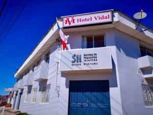 Biały budynek z znakiem na górze w obiekcie Hotel Vidal w mieście Pichilemu