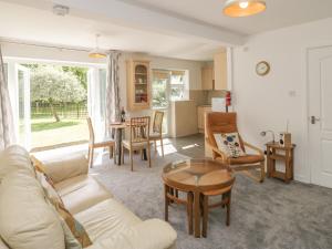 a living room with a couch and chairs and a table at Orchard Annexe in Lymington