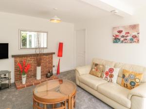 a living room with a couch and a fireplace at Orchard Annexe in Lymington
