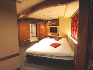 a bedroom with a large bed and a television at 都電屋 TodenHotel in Tokyo