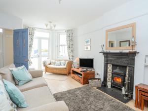 a living room with a fireplace and a tv at Ty Haf in Rhosneigr