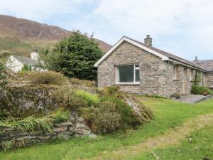 a stone cottage on the side of a hill at Rock Cottage in Keswick