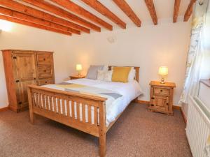 ein Schlafzimmer mit einem Bett und zwei Nachttischen in der Unterkunft Old Hall Barn 3 in Church Stretton