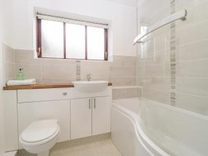 a bathroom with a toilet and a sink and a tub at The Forge in Winscombe +29 photos