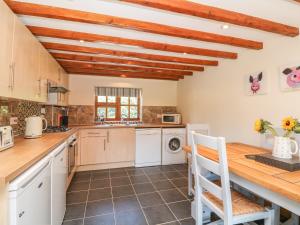 a large kitchen with a wooden counter top and a wooden table at Old Hall Barn 3 in Church Stretton