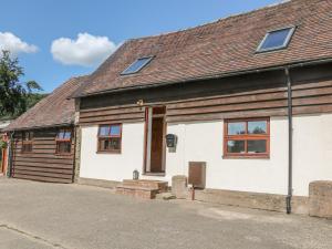 a white house with a wooden roof at Old Hall Barn 3 in Church Stretton