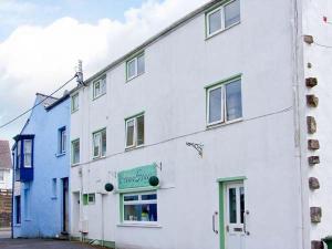 a white building with a sign on the side of it at The Old Brewery in Saundersfoot
