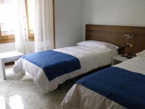 Habitación de hotel con 2 camas y ventana en Pensión Arroniz, en Arróniz