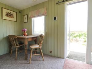 a dining room with a wooden table and chairs at Crows Cabin in Gloucester