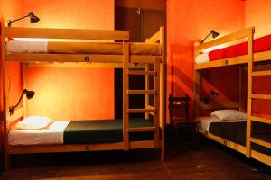 two bunk beds in a room with an orange wall at KACLLA, The Healing Dog Hostel in Lima