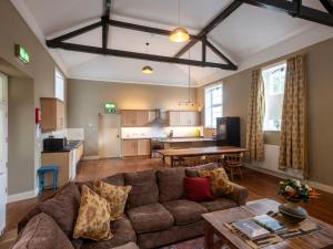 a living room with a couch and a kitchen at The Old School in Omagh