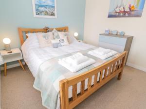 a bedroom with a large bed with two towels on it at Grebe Cottage in Oban