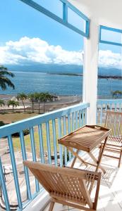 balcón con mesa, sillas y vistas al océano en Ocean View and Exclusive Flat Le croisieriste en Pointe-à-Pitre