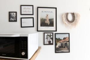 a wall with framed pictures and a microwave at Ocean View and Exclusive Flat Le croisieriste in Pointe-à-Pitre