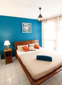 1 dormitorio con 1 cama grande y pared azul en Ocean View and Exclusive Flat Le croisieriste en Pointe-à-Pitre