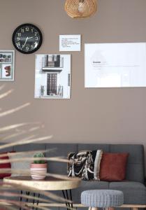 a living room with a couch and a clock on the wall at Ocean View and Exclusive Flat Le croisieriste in Pointe-à-Pitre +6 photos