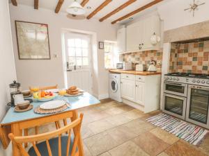 a kitchen with a table and a counter top at Cutlers Cottage in Matlock +12 photos