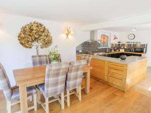 a kitchen and dining room with a wooden table and chairs at Nant Y Gwernan in Dolgellau