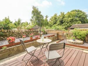 a patio with a table and two chairs on a deck at Cutlers Cottage in Matlock