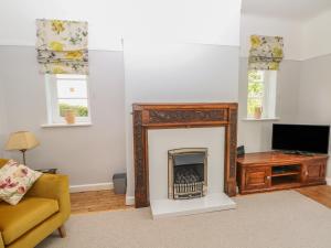 a living room with a fireplace and a tv at Ingledene in Highpeak Junction