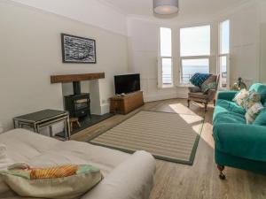 Una sala de estar con un sofá y una chimenea. en 11 Marine Terrace, en Criccieth