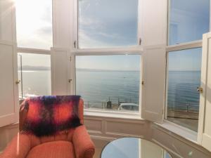 a room with a window with a chair and a table at 11 Marine Terrace in Criccieth