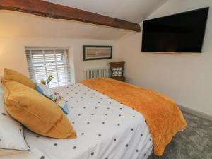 een slaapkamer met een bed en een flatscreen-tv bij Cockle Bay Cottage in Morecambe