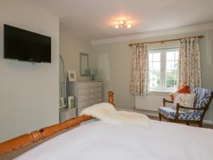 a bedroom with a bed and a tv on the wall at Homelea in Newquay