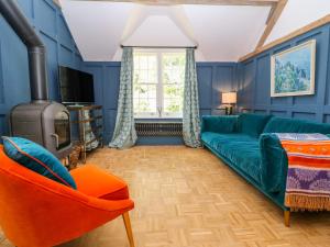 a living room with a green couch and a fireplace at The Hemmel in Faringdon