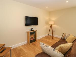 a living room with a couch and a fireplace at Ferngrove Cottage in Bishop Auckland