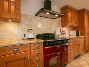 a kitchen with wooden cabinets and a stove top oven at Homelea in Newquay