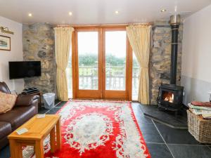 a living room with a couch and a fireplace at Dysynni in Tywyn