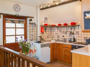 a kitchen with a sink and a stove at The Coach House in Kingsbridge