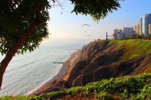 a group of kites flying over the ocean next to a beach at KACLLA, The Healing Dog Hostel in Lima