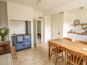 a kitchen with a wooden table and a blue stove at Wren Cottage in Oakham