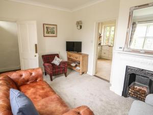 a living room with a couch and a fireplace at Wren Cottage in Oakham