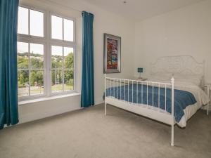 Un dormitorio con una cama y una ventana grande. en Cherrywood Manor, en Bodmin