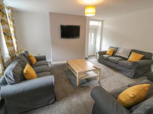 a living room with two couches and a tv at Lister Cottage in Halifax