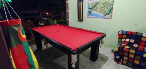 a red pool table in a room with a chair at Pousada Bem te vi in Garopaba